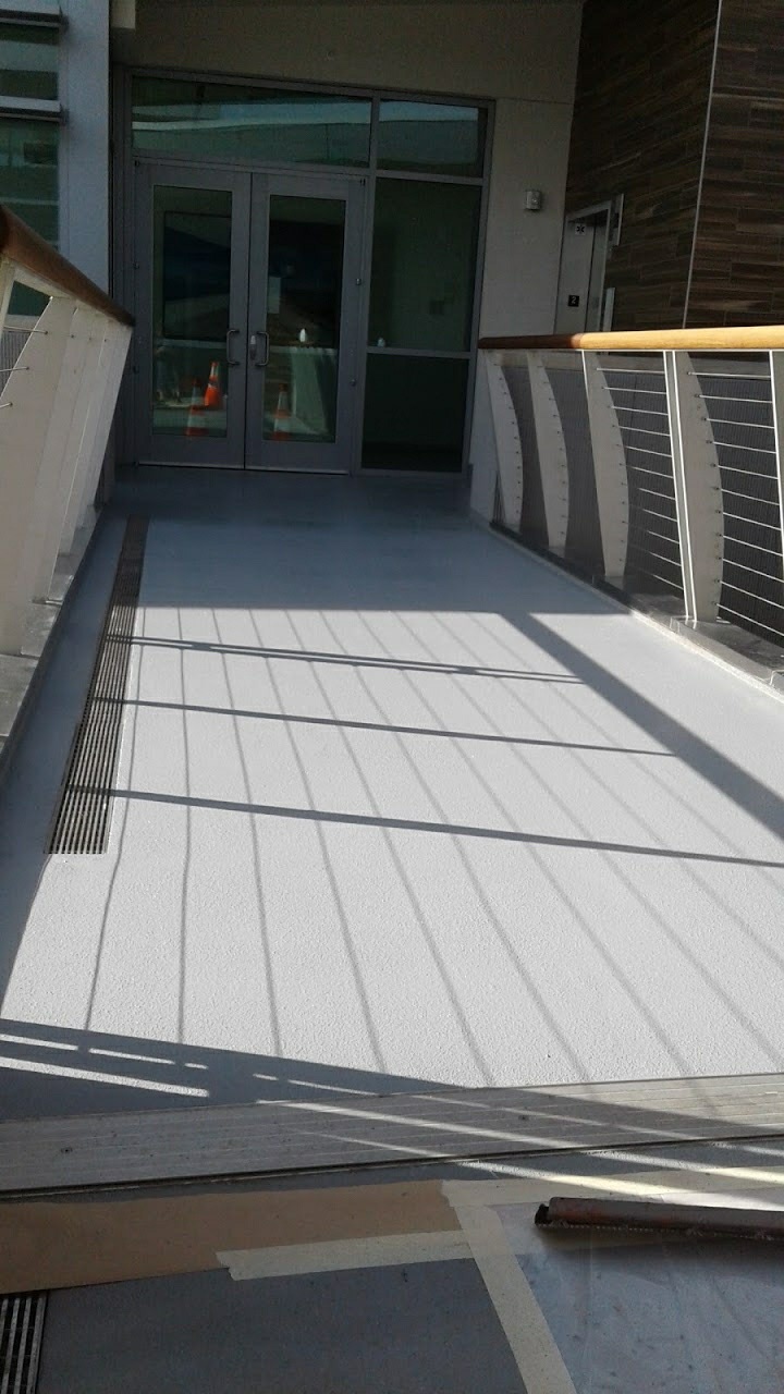 Protective coating applied to a walkway deck with metal railing